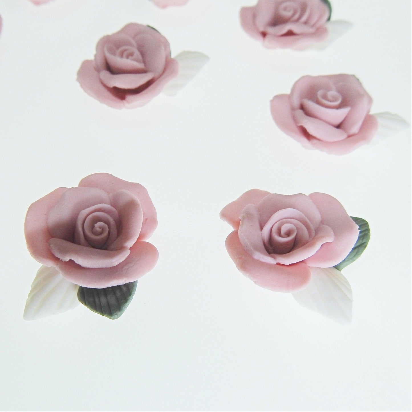 Dusty pink flower cabochons, made from matte bisque ceramic clay with white and green leaves for gluing on DIY jewelry. Lot of 10, 23-25m