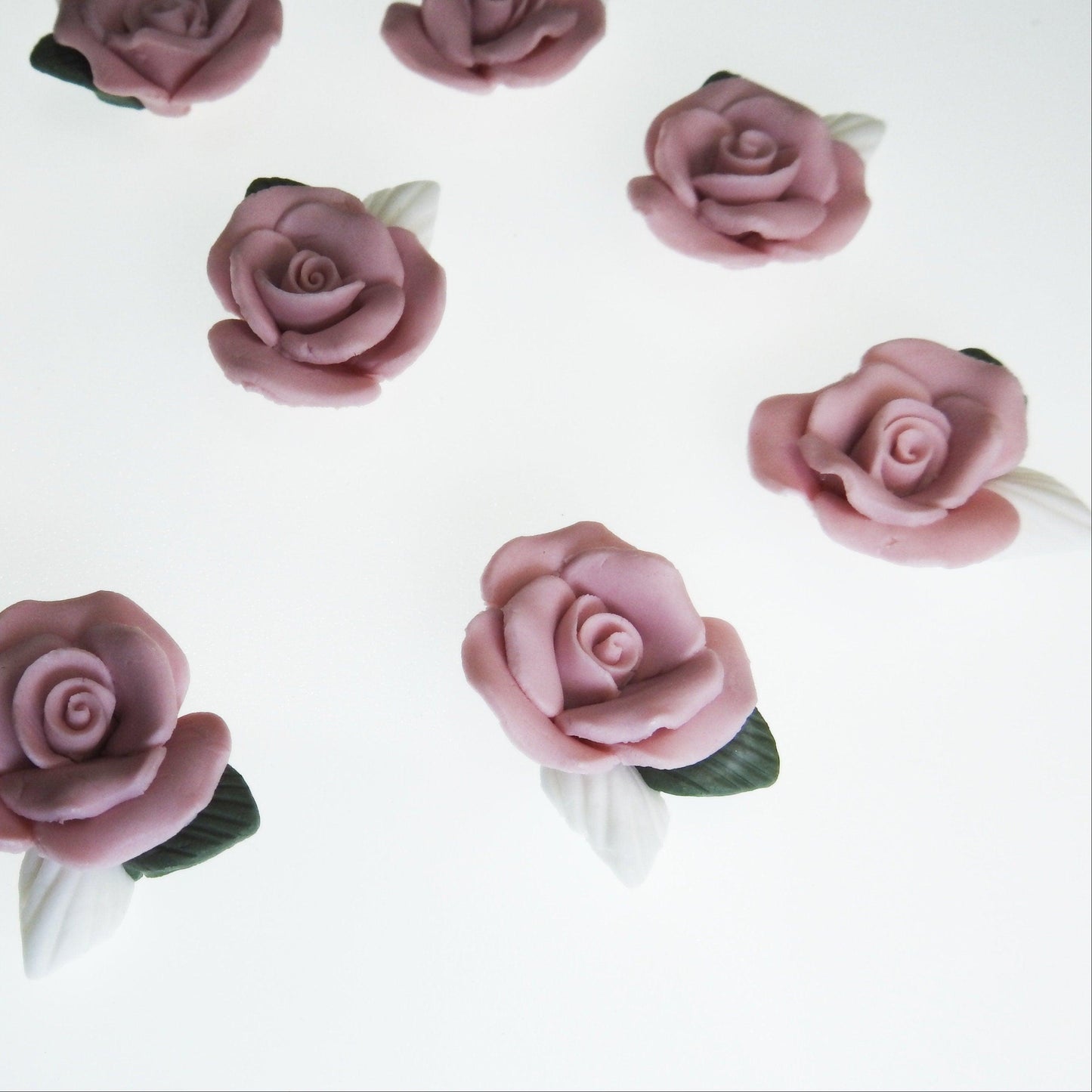 Dusty pink flower cabochons, made from matte bisque ceramic clay with white and green leaves for gluing on DIY jewelry. Lot of 10, 23-25m