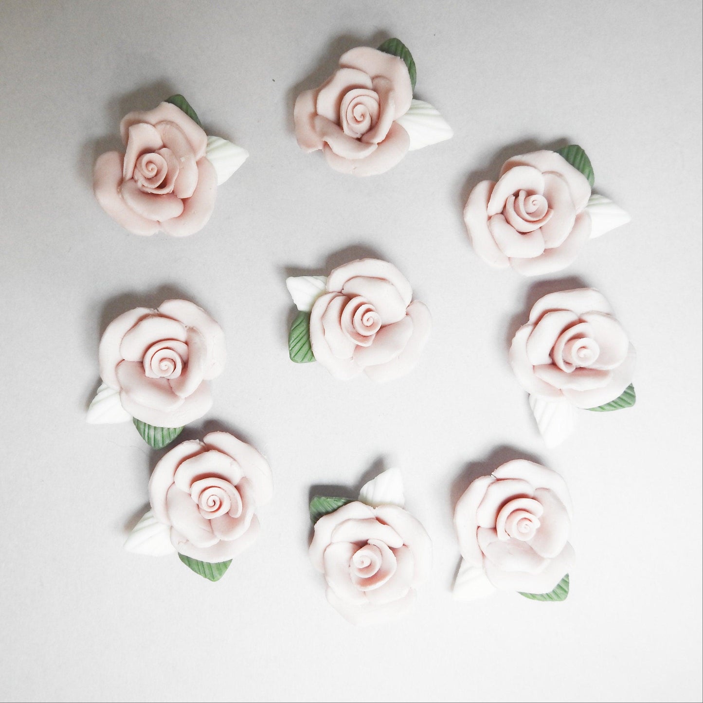 Dusty pink flower cabochons, made from matte bisque ceramic clay with white and green leaves for gluing on DIY jewelry. Lot of 10, 23-25m