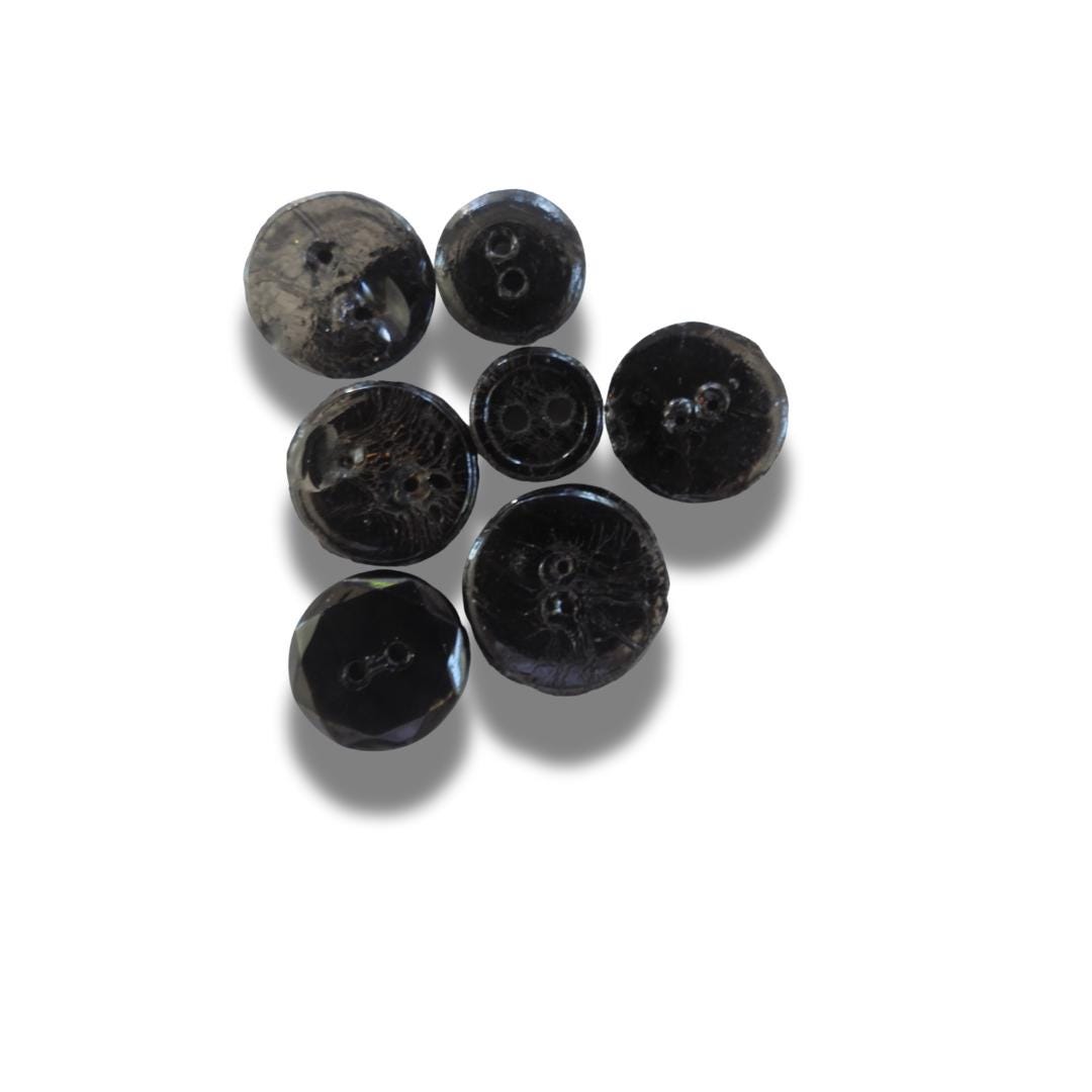 Set of 7 antique Victorian black glass buttons for sewing - 2-hole, 8–15 mm, Czech molded glass. Glossy floral & geometric patterns
