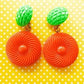 Bold and funky 1980s-inspired large neon dangle clip earrings in green and orange. Lightweight, Retro party-perfect and gift-ready