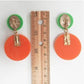 Bold and funky 1980s-inspired large neon dangle clip earrings in green and orange. Lightweight, Retro party-perfect and gift-ready