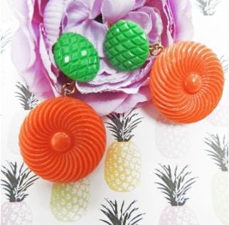 Bold and funky 1980s-inspired large neon dangle clip earrings in green and orange. Lightweight, Retro party-perfect and gift-ready