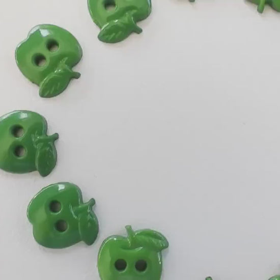 Set of 12 green apple-shaped buttons for sewing and crafting. 2-hole design